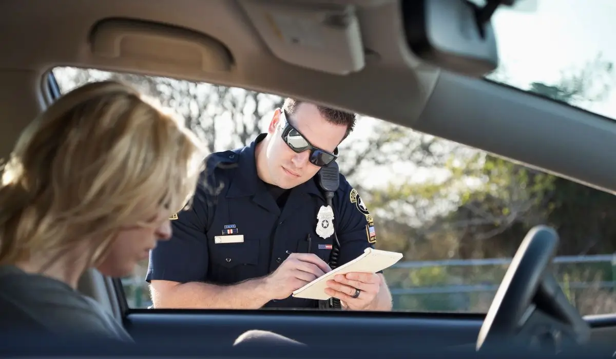 Police officer writes a ticket during a roadside stop involving Drug-Related DUI Charges in Illinois.