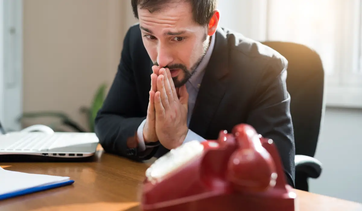 A worried man near a phone, anticipating next steps after being arrested in Illinois.